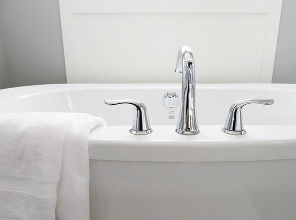 close up of white bathtub with white towel